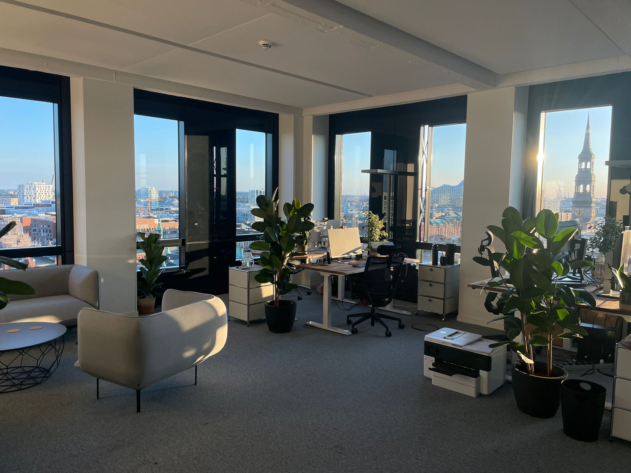 Helles Hamburger Office mit Arbeitsplätzen, Pflanzen und Blick über die Stadt
